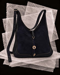 Andrea bag in Slate with the Plata amulet, a hammered silver disc on a slate leather cord